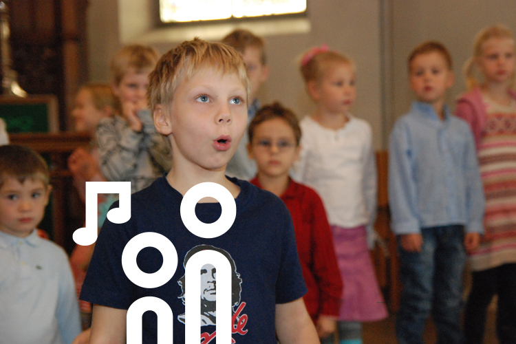 Kuva laulavista lapsista kirkon kuoressa.